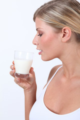 Beautiful blond woman holding glass of milk