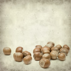 textured old paper background with  shiny ripe hazelnuts