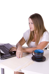 Businesswoman  working on laptop with cup of coffee on her desk