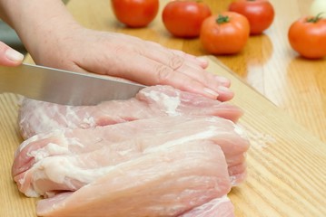 preparing meat on cutting board.
