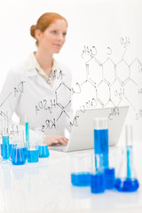 Woman scientist in laboratory with laptop