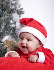 joli bébé riant devant le sapin de noël