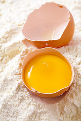 Broken egg with shells on flour