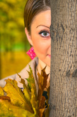 young woman behind the tree