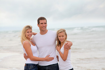 Couple and daughter standing by the sea