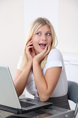 Blond businesswoman doing funny faces in the office