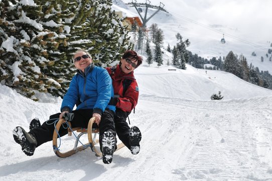 Senior Couple On Sledge Having Fun