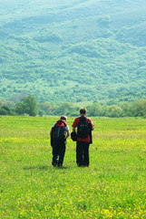Fototapeta na wymiar Tourists in mountain meadow