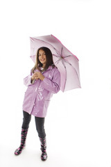 A pretty young girl in a raincoat and holding an umbrella