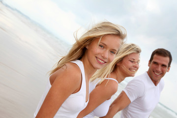 Obraz premium Family walking hand to hand on a sandy beach