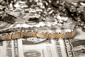 Golden bracelet  and other jewelry at money background