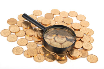 Magnifier and coins on white background