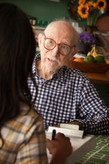 Elderly man in home with care provider or survey taker