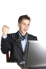 young man in a suit sitting next to laptop