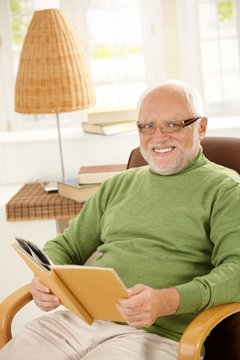 Portrait of happy pensioner relaxing with book