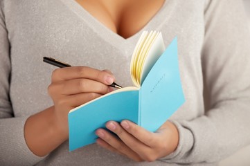 young woman writes in the notebook