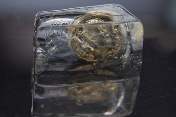 One pound coin in a block of ice
