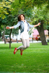 Fototapeta premium young woman jamping on a grass