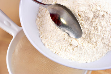 Mehl wird mit einem Sieb gesiebt