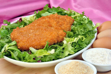 panierte Hühnerfilets auf grünem Salat