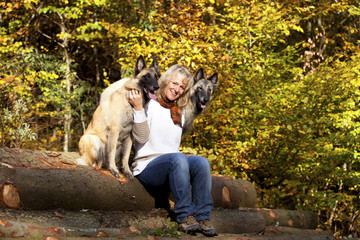 lächelnde blonde Frau mit ihren belgischen Schäferhunden