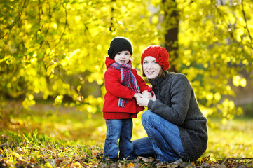 Fototapeta premium Young mother and her toddler girl in autumn