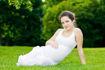 Beautiful pregnant woman relaxing in the park