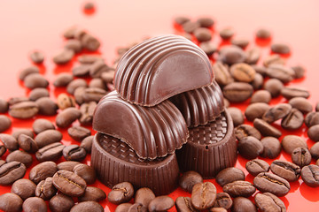 Chocolate and coffee beans on red background