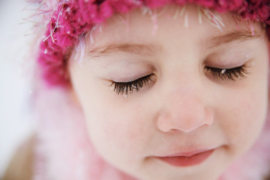 Young girl with snowflakes on eyelashes