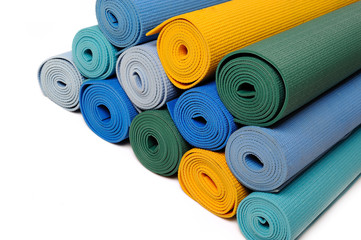 many colorfull yoga mats as a background. isolated on white back