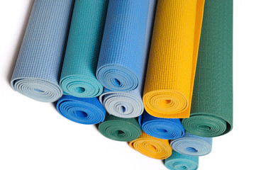 many colorfull yoga mats as a background. isolated on white back