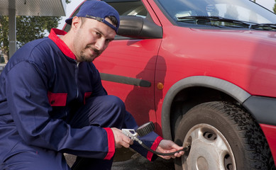 Mechanic Checking Tyre Pressure at Gas Station