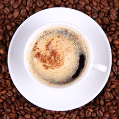 Cup of coffee with sprinkled with cinnamon with coffee beans