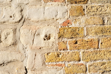 Old pastel yellow brick wall, grunge background