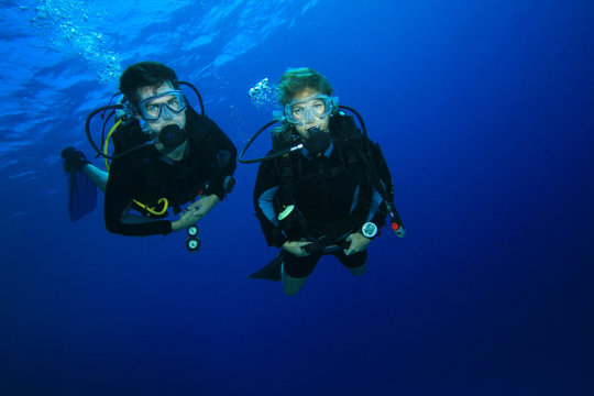 Couple scuba diving on a coral reef © Richard Carey