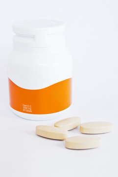 vitamin c bottle and medicine tablets isolated