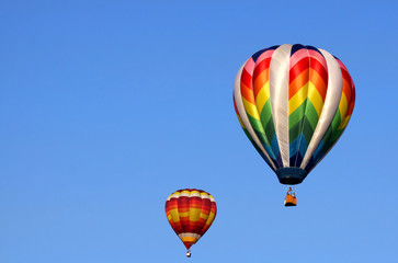 Two colorful hot air balloons in the blue sky