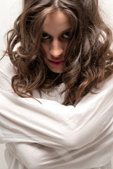 Young insane woman with straitjacket looking at camera close-up