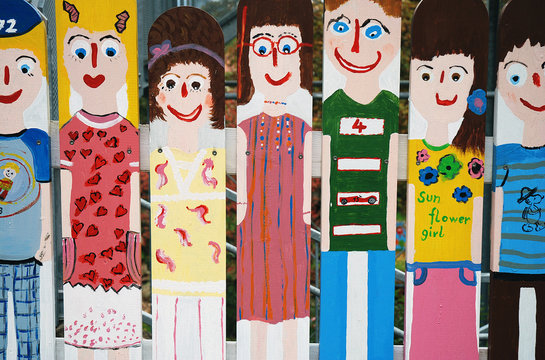 Colorful kids drawings on a wooden fence - bunte Kinderzeichnung am Holzzaun