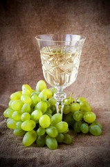 White wine and white grape on the dark background