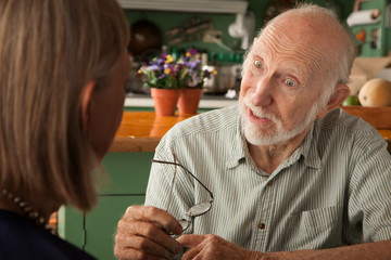 Senior couple at home focusing on man