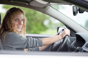 Naklejka premium Pretty young woman driving her new car