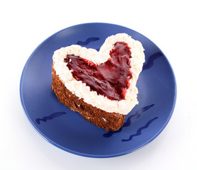 sweet cake in heart shape on blue plate