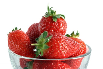 Few strawberries in glass cup isolated on white