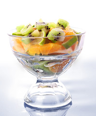 Cup with orange, kiwi and lime on blue