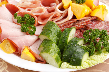 Meat and sausages with parsley and vegetables on white plate