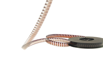 stack of old movie film on plastic reel on white