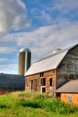 Fototapeta na wymiar Farm Buildings with Blue Sky and Green Grass