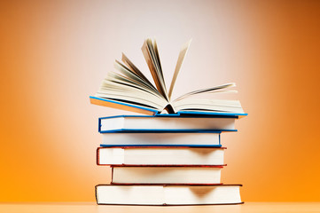 Stack of text books against gradient background