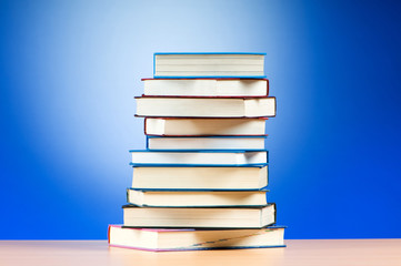 Stack of text books against gradient background